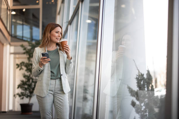 istock Smiling businesswoman using phone in office 2042565485