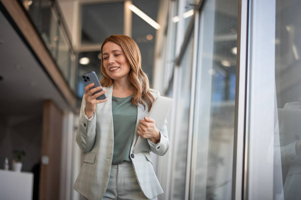 Smiling businesswoman using phone in office