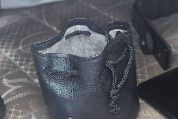 This special bag for storing lenses is made of black leather and the inside is made of very soft material. The way to insert items and then close them is by pulling the strap.