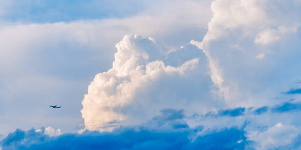 istock A soaring plane in the blue sky and clouds 2042581760