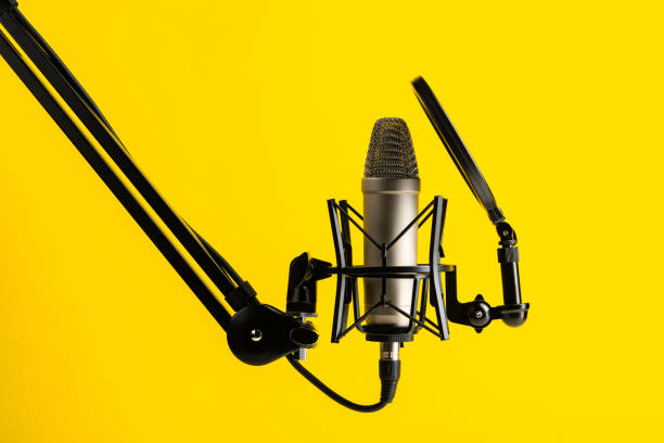 professional microphone stand over yellow studio background - microphone mid air recording studio radio station 뉴스 사진 이미지