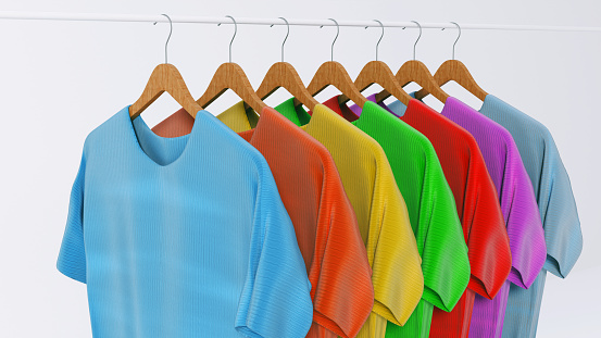 Colorful tshirts hang next to each other on a rack. Concep of picking and choosing the right one to wear.