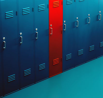 Locker room full of blue lockers, but one stands out and it is red. Concept of being different, individuality and making the right choice.