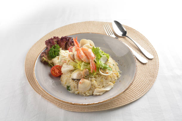 istock chef wok egg fried rice with seafood prawn, octopus and fish with salad in plate on white table restaurant asian cafe chinese banquet halal menu 2042631750