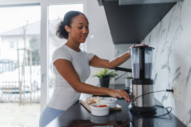 istock Young Woman Making Smoothie at Home 2042654570