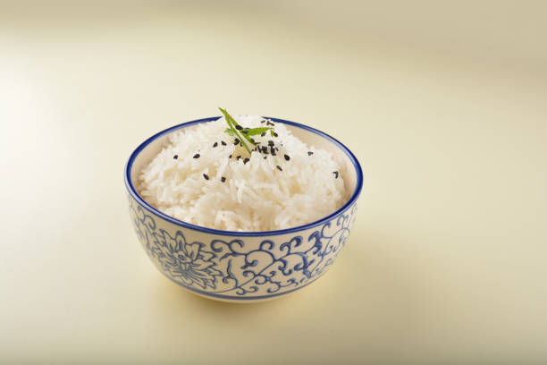 Close up background of white rice in a bowl on a wooden table