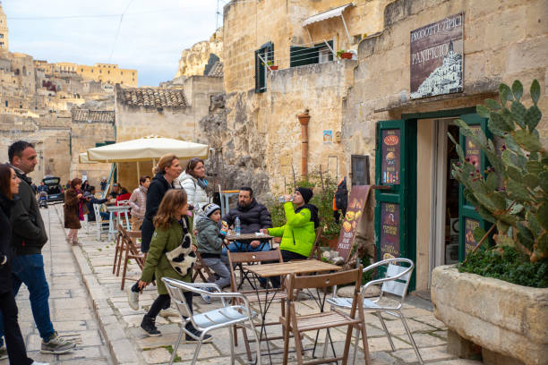 Matera, Italy–Dec 30, 2023: Tourists enjoy vacation in a cave bar