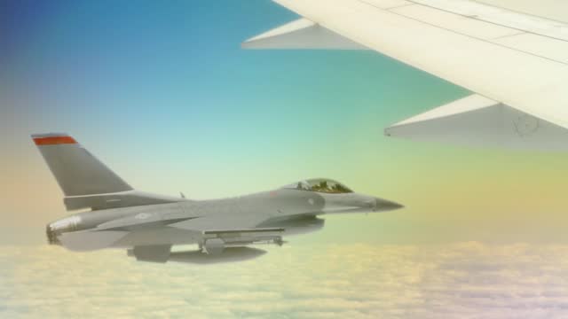 Fighter jet flying beside a passenger jet.