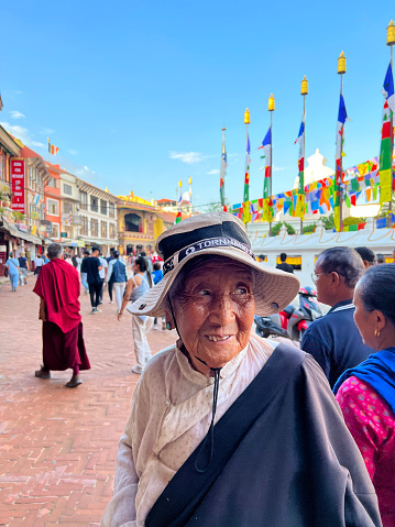 asian old woman is on street focus on foreground people are walking at ackground vertical still Katmandu Nepal June 2023
