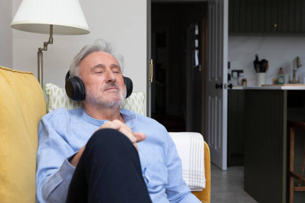 istock Man wearing headphones is relaxing on a sofa 2042679963