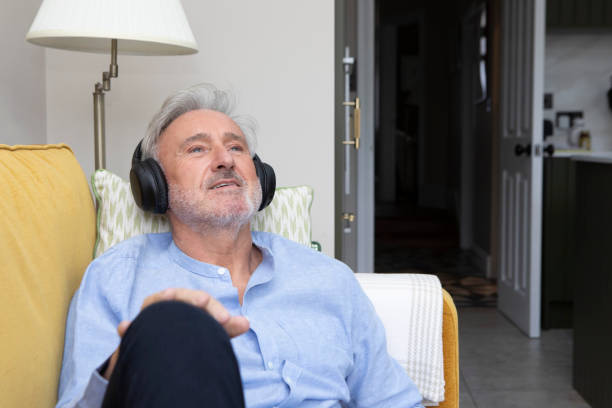 istock Man wearing headphones is relaxing on a sofa 2042680497