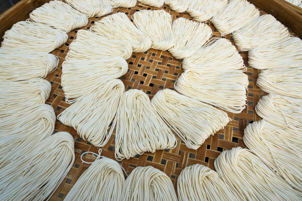 Freshly prepared raw pasta noodles in a close-up view, showcasing their smooth texture, golden hue, and intricate spirals. Perfect for a culinary setting or food presentation.