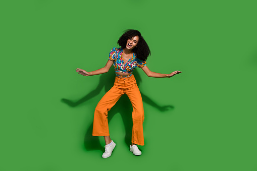 Full body size photo of young hipster girl wearing vintage outfit dancing chilling vibes dancer isolated on green color background.