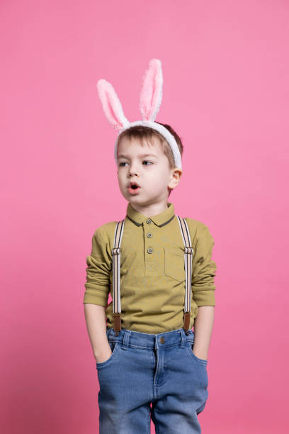 istock Smiling excited child wearing fluffy bunny ears in studio 2042721391
