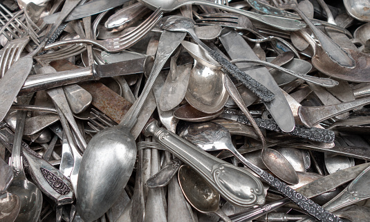A large pile of old and antique cutlery for sale at the flea market