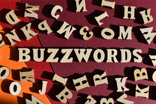Buzzwords, word in wooden alphabet letters surrounded by random letters on background as banner headline