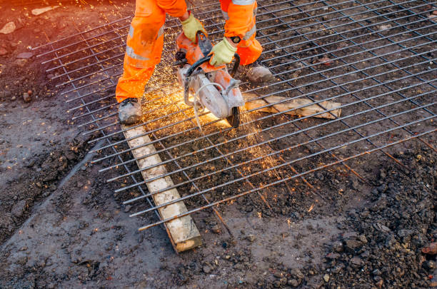 builder cutting steel mesh with petrol-powered steel saw and creating a lot of sparks - confined space flash imagens e fotografias de stock
