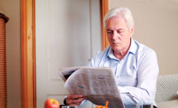 istock Man reading newspaper at home 2042764272
