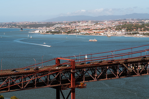 Aerial view of April 25th bridge crossing the Tagus river with Lisbon, Portugal in the background.