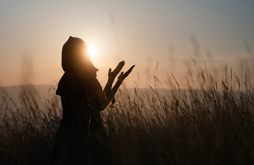 Silhouette of Muslim woman praying