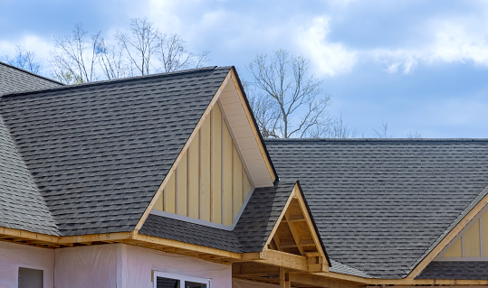 On newly constructed home, overlapping asphalt shingles are seen on roof