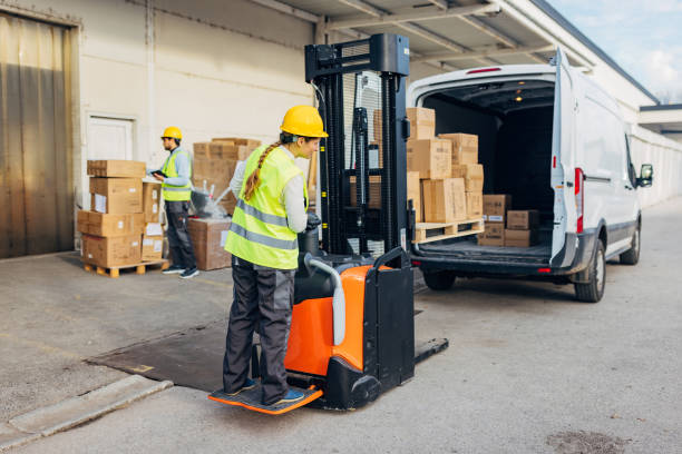 istock A female warehouse worker uses a forklift to load cardboard boxes into a delivery van 2042831783