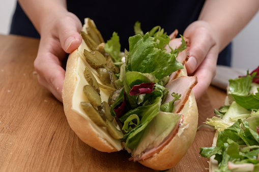 Folded roll with lettuce, cold meat, cucumber and cheese , close-up sandwiches