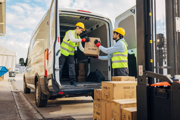 istock Two workers are transferring cardboard boxes from a forklift to a delivery van, they are preparing packages for shipping 2042849839