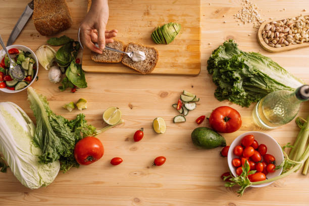 istock Lady spreading sauce on bread for vegetarian sandwich on wooden table 2042853679