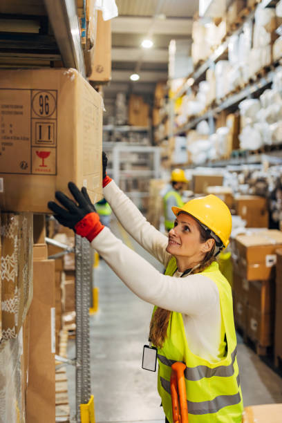 istock A woman worker in a reflective uniform arranges cardboard boxes in a wholesale warehouse 2042855098