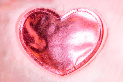 Red heart sewn onto pink faux fur.