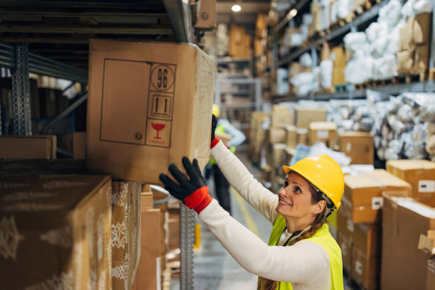 istock A cheerful female worker removes a cardboard box from a shelf in a warehouse 2042871308