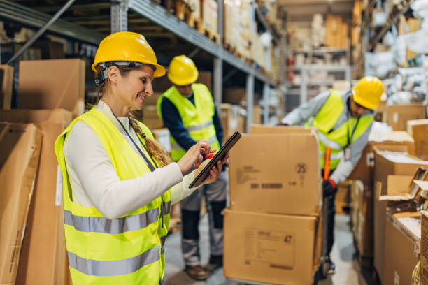 istock Female warehouse supervisor and workers work in warehouse, arrange packages and prepare shipments 2042873119