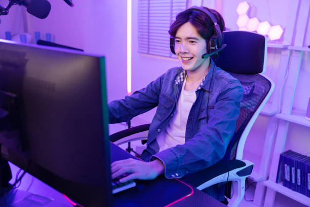 istock Asian Gamer Playing PC Game with Mouse and Keyboard in Neon Game Room 2042874731