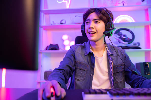 istock Male Gamer Playing PC Game with Mouse and Keyboard in Neon Game Room 2042875258