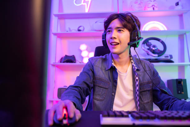 istock Male Gamer Playing PC Game with Mouse and Keyboard in Neon Game Room 2042875263