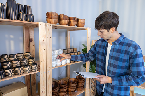 Male Owner of Vase Online Selling Shop Checking the Stock on the Shelf