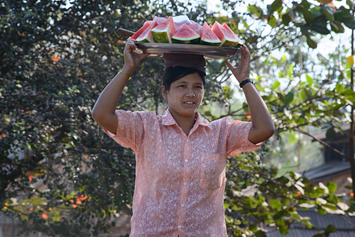 02/22/2014 - Yangon, Myanmar: Woman selling fresh watermelon slices on the streets of Yangon