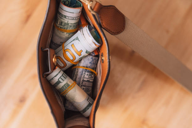 istock Rolled up banknotes in a woman's shoulder bag 2042900016