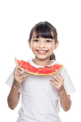 Young Asian girl eating watermelon isolated on white background with clipping path.