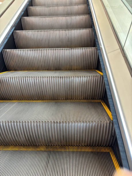 Close-up of an empty escalator in motion, showcasing the steps and textured surface, suitable for modern urban settings.