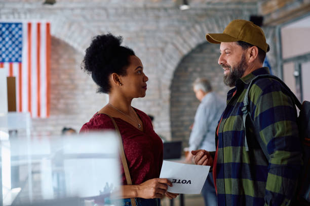 istock Multiracial US citizens talking while voting at polling place during elections. 2042924619