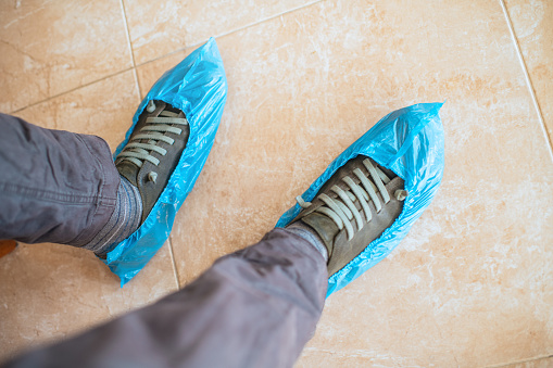Blue shoe covers on a man's shoes