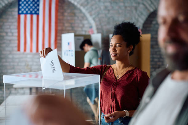 istock African American citizen casting her vote during US elections at polling place. 2042934347