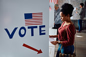 Black mid adult woman at voting booth on USA election day.