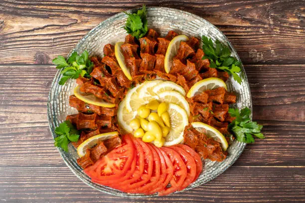 Çi Köfte. Traditional middle eastern cuisine. Çi köfte or turkish raw meatballs ready to serve on a plate. Top view