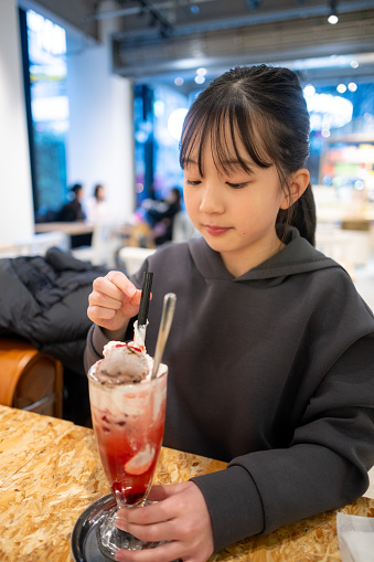 Teenage girl drinking strawberry float in cafe
