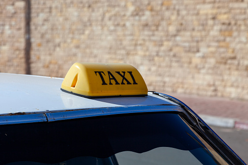 Close-up on a yellow taxi sign in Essaouira, Morocco.