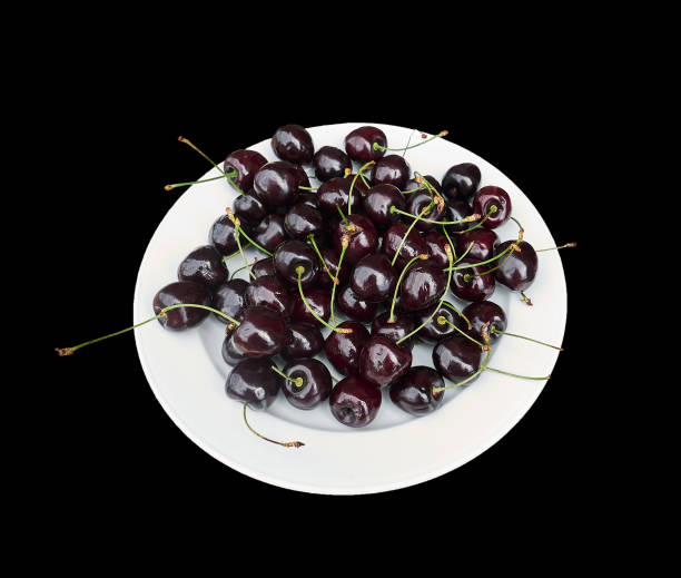 Plate with ripe burgundy cherries, close up isolated on black. stock photo