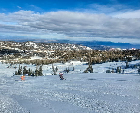 Brian Head, Utah, USA- February 19, 2024: Snowboarders on a groomed run. Brian Head ski resort, Utah.